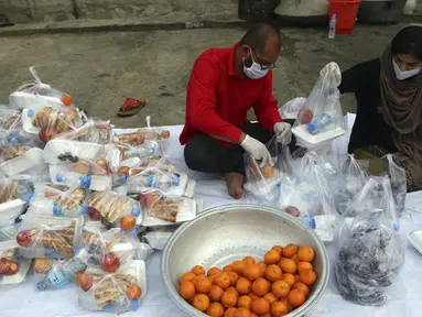 Sukarelawan menyiapkan makanan berbuka puasa gratis untuk orang-orang yang membutuhkan selama bulan puasa suci Ramadan di Kabul, Afghanistan, Kamis (7/5/2020). Muslim di seluruh dunia melewati Ramadan tahun ini di tengah pandemi virus corona COVID-19 dan PHK. (AP Photo/Rahmat Gul)