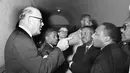 Panitera Carl Golson berbincang dengan Martin Luther King saat menggelar pertemuan di Hayneyville pada 1 Maret 1965. Beberapa bulan sebelum dibunuh, King merasa prihatin dengan masalah ketimpangan ekonomi di Negeri Paman Sam. (AP Photo/Horace Cort, File)