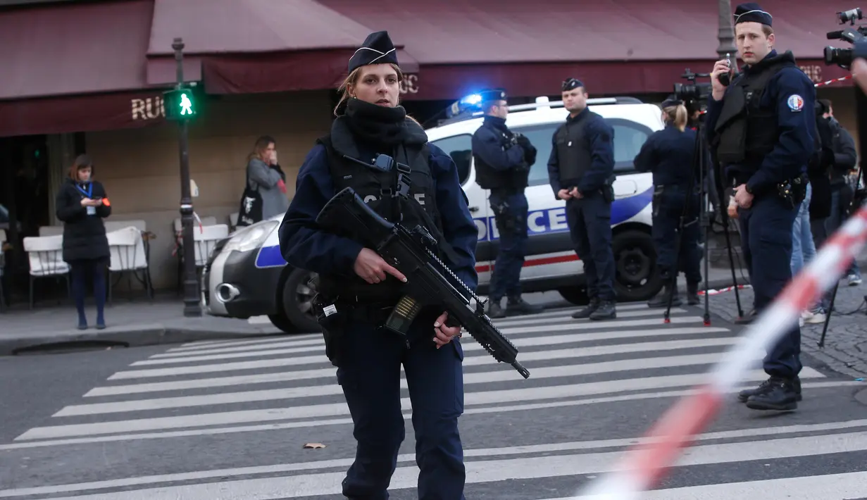 Seorang polisi wanita berjaga-jaga di sekitar Museum Louvre, Perancis, Jumat (3/2). Daerah di sekitar Museum Louvre telah diamankan dan tertutup untuk sementara. (AP Photo/Thibault Camus)