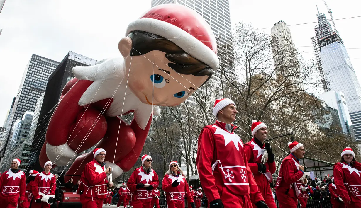 Peserta  membawa balon tokoh peri, Elf on the Shelf untuk memeriahkan parade perayaan Hari Thanksgiving di kawasan Sixth Avenue, New York, Kamis (28/11/2019). Parade yang membelah jalanan kota New York ini selalu ditunggu setiap tahunnya. (AP Photo/Jeenah Moon)