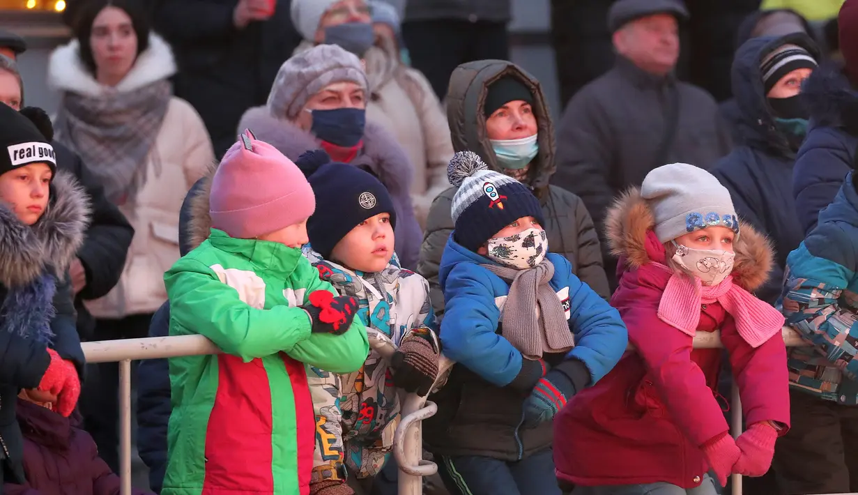 Orang-orang menyaksikan pertunjukan drama outdoor untuk menyambut Tahun Baru mendatang di sebuah lapangan di pusat kota Minsk, Belarus, pada 26 Desember 2020. Berdasarkan data per Kamis (26/12), total kasus Covid-19 di Belarusia yang telah dikonfirmasi mencapai 184.922 kasus. (Xinhua/Henadz Zhinkov)