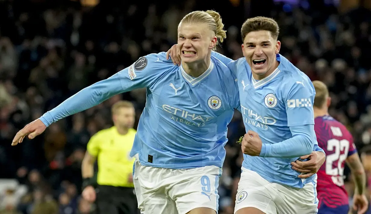 Pemain Manchester City, Erling Haaland (kiri) melakukan selebrasi bersama Julain Alvarez setelah mencetak gol ketiga timnya ke gawang RB Leipzig pada laga lanjutan Grup G Liga Champions 2023/2024 yang berlangsung di Etihad Stadium, Manchester, Rabu (29/11/2023). (AP Photo/Dave Thompson)