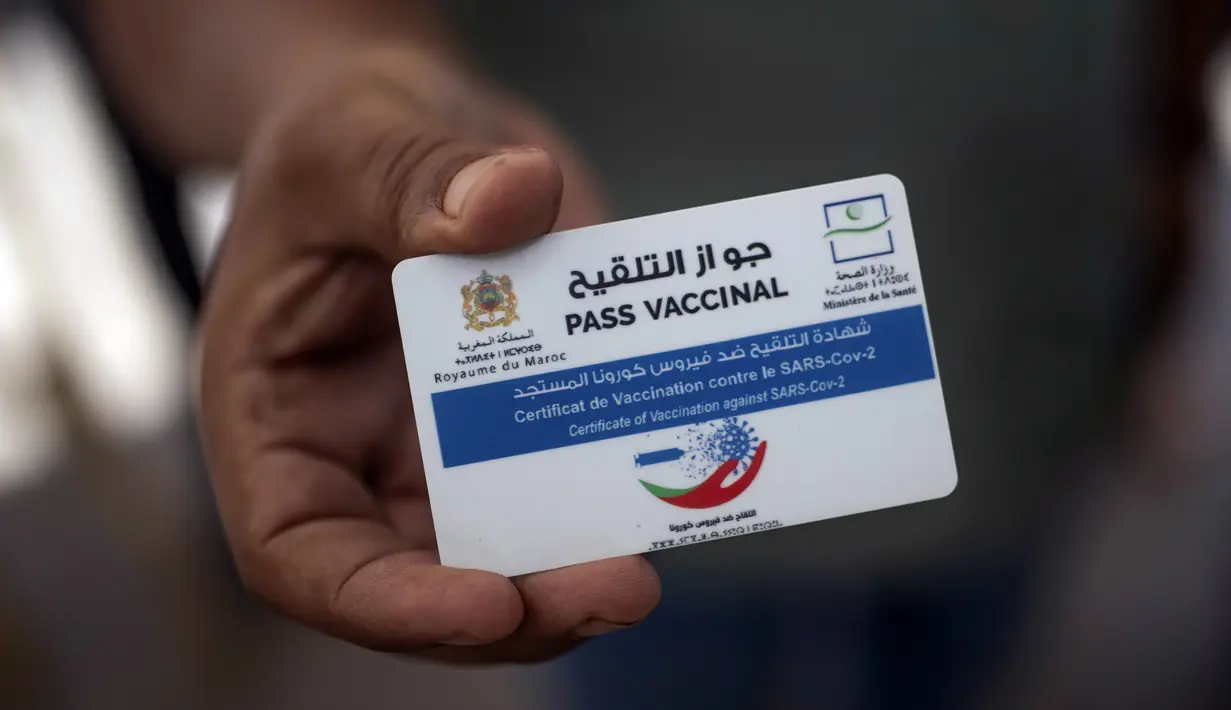 Seorang pria menunjukkan paspor vaksinnya sebelum diizinkan memasuki kantor pemerintah, di Rabat, Maroko, Kamis (21/10/2021). Maroko mewajibkan paspor vaksin untuk mengakses kantor pemerintah, mal, pusat kebugaran, dan area publik lain untuk mendorong kampany vaksinasi. (AP Photo/Mosa'ab Elshamy)