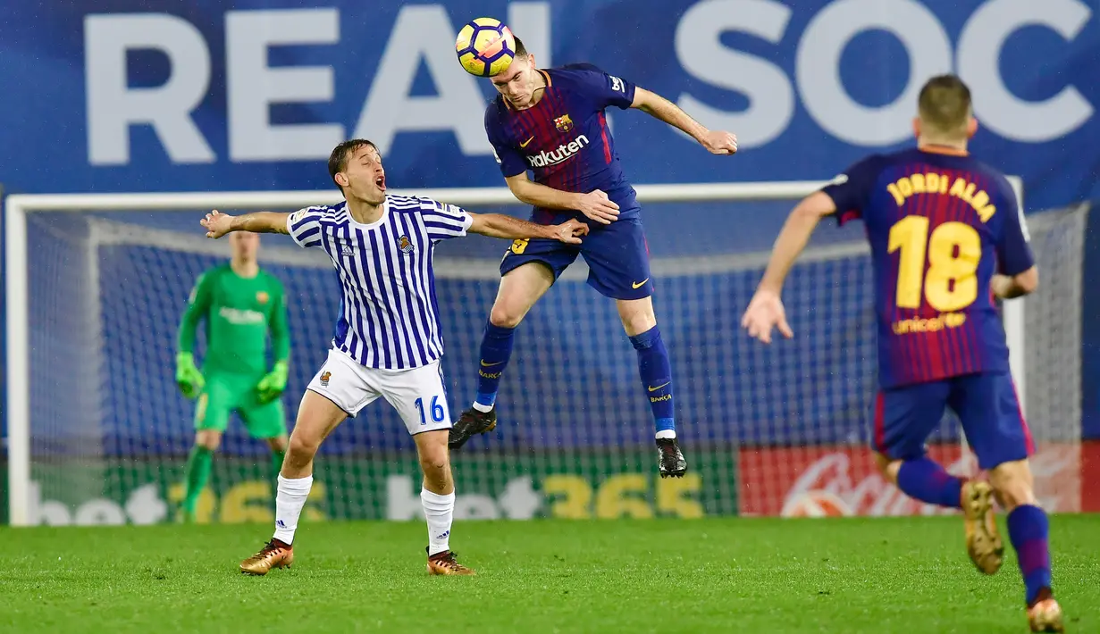 Pemain Barcelona, Thomas Vermaelen berebut bola dengan pemain Real Sociedad, Sergio Canales pada laga pekan ke-19 La Liga di Stadion Anoeta, Minggu (14/1 Sempat tertinggal dua gol, Barcelona akhirnya menang 4-2. (AP/Alvaro Barrientos)