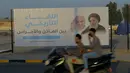 Sebuah papan reklame yang menampilkan gambar Paus Fransiskus dan ulama terkemuka Irak Ayatollah Ali al-Sistani, di Najaf, Irak, Kamis (4/3/2021). Pemimpin Tertinggi Umat Katolik Paus Fransiskus akan melakukan perjalanan bersejarah ke Irak pada Jumat (5/3/2021) waktu setempat. (AP Photo/Anmar Khalil)