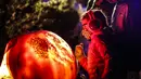 Pengunjung mengamati ukiran labu dalam acara Malam 1.000 Jack-O'-Lantern di Chicago Botanic Garden, Glencoe, Illinois, Amerika Serikat, 24 Oktober 2020. Lebih dari 1.000 labu ukiran tangan dipamerkan di acara tersebut menjelang perayaan Halloween. (Xinhua/Joel Lerner)