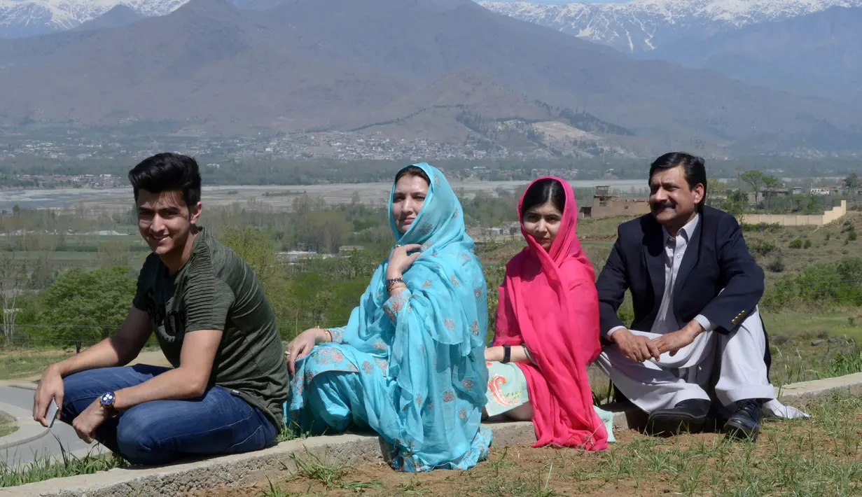Aktivis Pakistan dan penerima Nobel Perdamaian Malala Yousafzai berfoto bersama kedua orang tua dan saudaranya saat mengunjungi kampung halamannya di Kota Swat, Pakistan (31/3). (AFP Photo/Abdul Majeed)