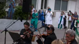 Para anggota ERT (Hellenic Broadcasting Corporation) Modern Music Orchestra memainkan musik di halaman Rumah Sakit Umum Evaggelismos di Athena, Yunani (20/4/2020). Konser digelar oleh ERT Modern Music Orchestra untuk menghormati staf medis dalam perjuangan melawan COVID-19. (Xinhua/Marios Lolos)