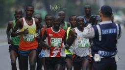 Petugas Dishub memfoto pelari lomba lari Milo Jakarta International 2017 di kawasan Kuningan, Jakarta, Minggu (23/7/2017). Ajang lomba lari tersebut diikuti 15.000 peserta dengan kategori 5K, 10K dan Family Run 1,7K. (Bola.com/M Iqbal Ichsan)
