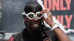 Gelandang Manchester United asal Prancis, Paul Pogba merapikan kaca mata yang diberikan fans selama pertemuan dengan para penggemarnya pada juma pers di Seoul, Korea Selatan, Kamis (13/6/2019). Paul Pogba berada di Seoul sebagai bagian dari tur Asia-nya. (AP Photo/Lee Jin-man)