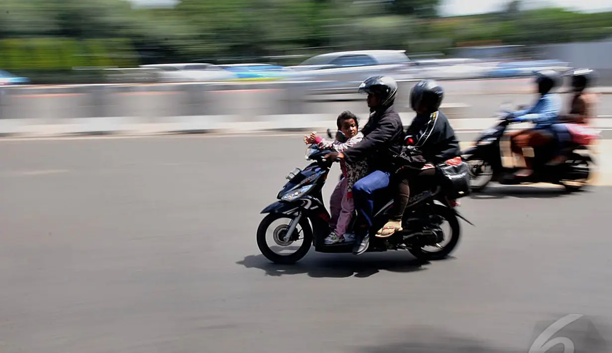 Seorang pengendara sepeda motor saat melintas di kawasan Bundaran Senayan, Jakarta, Jumat (9/1/2015). (Liputan6.com/Johan Tallo)