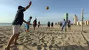 Orang-orang bermain voli pantai sembari menunggu waktu berbuka puasa selama bulan suci Ramadan, meskipun lockdown karena pandemi COVID-19, di ibu kota Tripoli, Libya pada Jumat (8/5/2020). (Photo by Mahmud TURKIA / AFP)