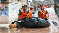Polisi paramiliter menyieir daerah yang banjir oleh hujan lebat di Chongqing barat daya China. (AFP)