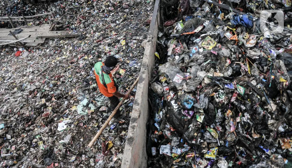 Pekerja Suku Dinas Lingkungan Hidup Kepulauan Seribu saat membersihkan sampah di kawasan Kali Baru, Cilincing, Jakarta Utara, Rabu (23/2/2022). Pembersihan dilakukan menyusul menumpuknya sampah di kampung tempat nelayan bermukim tersebut. (merdeka.com/Iqbal S. Nugroho)