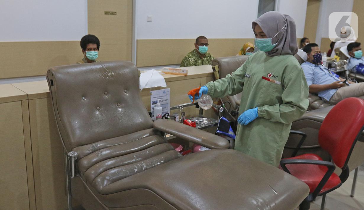 Petugas membersihkan tempat donor darah dengan cairan disinfektan di PMI DKI Jakarta, Jumat (20/3/2020). PMI DKI Jakarta memberlakukan disiplin saling menjaga jarak atau social distancing agar kegiatan donor darah tetap aman dan terhindar dari penularan COVID-19. (Liputan6.com/Herman Zakharia)