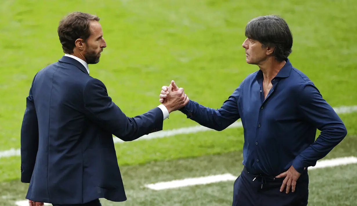 Manajer Inggris Gareth Southgate (kiri) berjabat tangan dengan manajer Jerman Joachim Loew pada akhir pertandingan babak 16 besar Euro 2020 antara Inggris dan Jerman di Stadion Wembley, London, Inggris, Selasa (29/6/2021). Inggris menang 2-0. (John Sibley/Pool via AP)