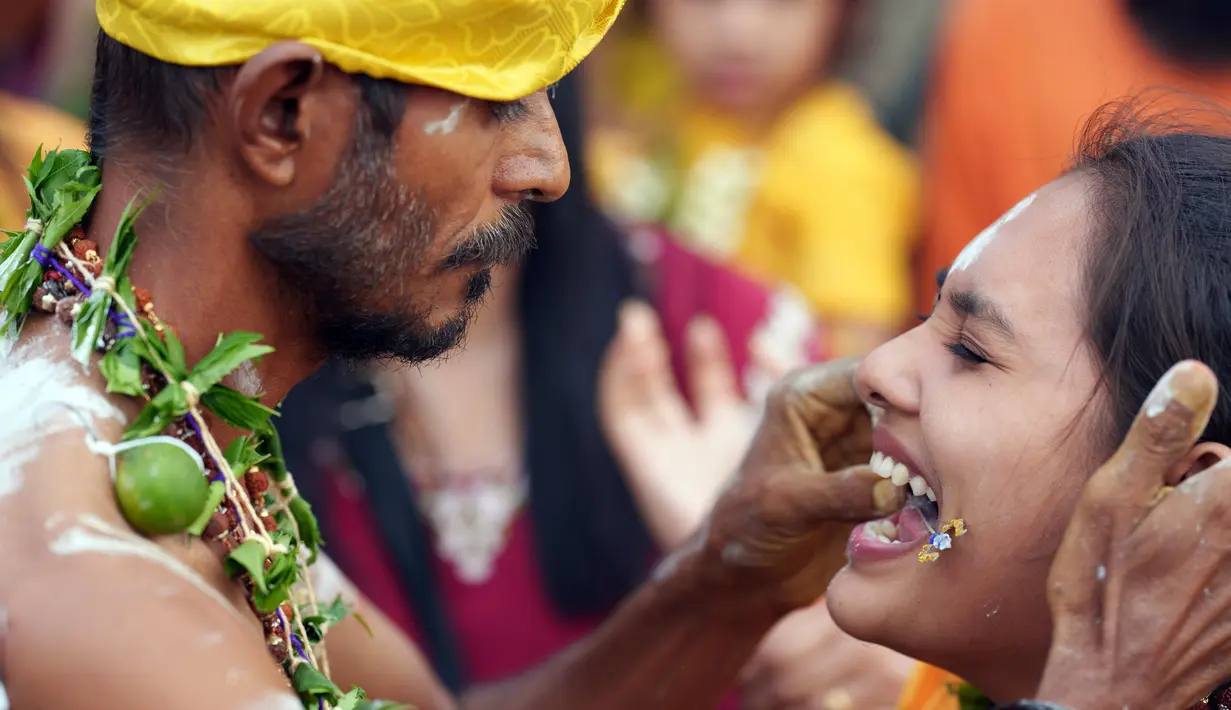 Seorang umat Hindu ditindik lidahnya dengan batang logam saat perayaan Thaipusam di Batu Caves, Kuala Lumpur, Malaysia, Minggu (5/2/2023). Thaipusam, yang dirayakan untuk menghormati Dewa Murugan, adalah acara tahunan umat Hindu untuk mencari berkah, memenuhi sumpah, dan mengucapkan terima kasih. (AP Photo/Vincent Thian)
