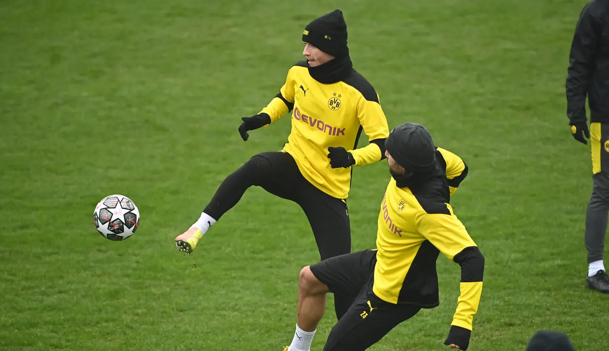 Penyerang Borrusia Dortmund, Marco Reus (kiri) berebut bola dengan gelandang Emre Can selama sesi latihan di tempat latihan tim di Dortmund, Jerman barat (9/3/2021). Borussia Dortmund sebelumnya berhasil mengalahkan Sevilla dengan skor 3-2 di leg pertama. (AFP/Ina Fassbender)