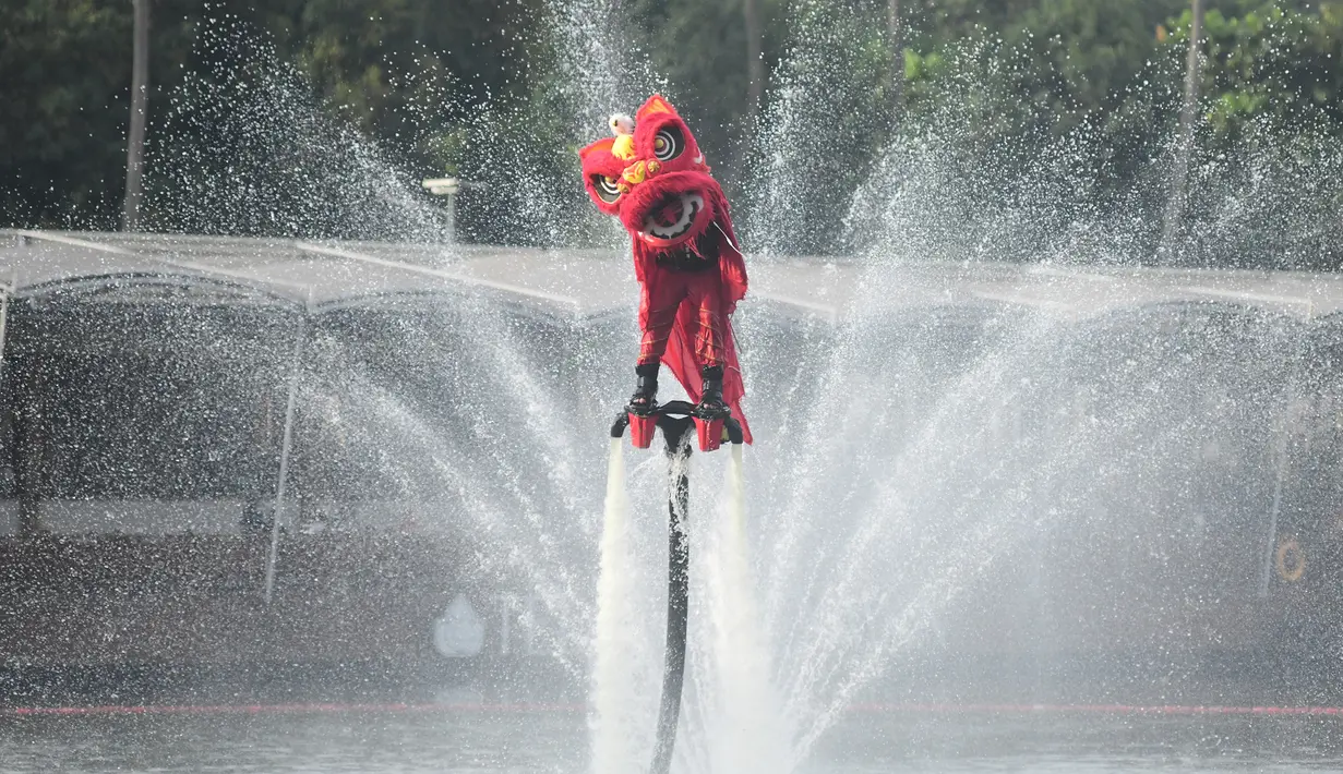Untuk menyemarakkan perayaan Tahun Baru Imlek 2577 Kongzili, pihak mal Senayan Park menyelenggarakan atraksi barongsai menari di atas air. Tampak dalam foto, penampil mengenakan kostum barongsai beratraksi Aerial Lion Dance di Danau Senayan Park, Jakarta, 14 Februari 2026. (merdeka.com/Arie Basuki)