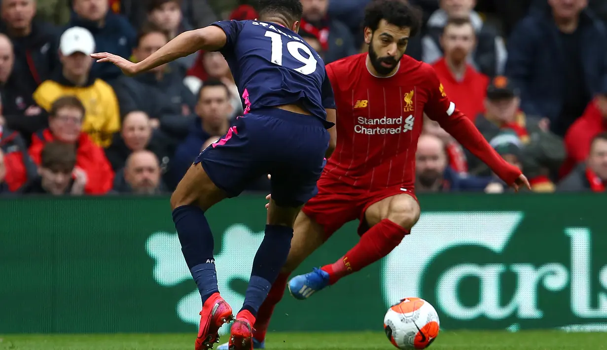 Gelandang Liverpool, Mohamed Salah, berebut bola dengan pemain Bournemouth pada laga lanjutan Premier League 2019-2020 di Anfield, Liverpool, Sabtu (7/3) malam WIB. Liverpool menang 2-1 atas Bournemouth. (AFP/Geoff Caddick)