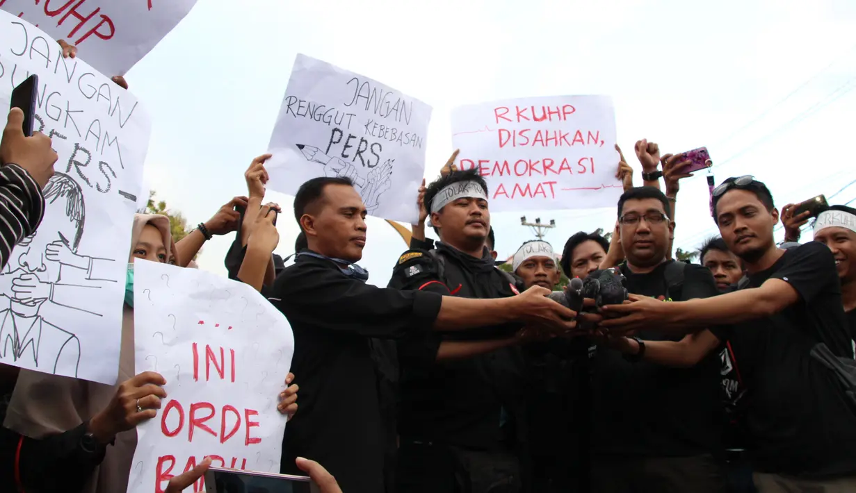 Massa yang tergabung dalam Aliansi Jurnalis Gorontalo melepaskan burung saat menggelar aksi menolak RUU KUHP di Gorontalo, Senin (23/9/2019). Menurut massa, RUU KUHP akan mencoreng Demokrasi Indonesia. (Liputan6.com/Arfandi Ibrahim)