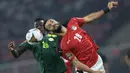 Striker Mesir, Marwan Hamdi (kanan) berduel udara dengan gelandang Senegal, Pape Gueye dalam laga final Piala Afrika 2021 di Stade d'Olembe, Yaounde, Kamerun (6/2/2022). (AFP/Kenzo Tribouillard)