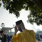 Umat Muslim yang mengenakan masker untuk meredam penyebaran wabah virus corona melaksanakan sholat Idul Fitri menandai akhir bulan suci Ramadhan di luar Masjid Nasional di Kuala Lumpur, Malaysia, Kamis (13/5/2021). (AP Photo/Vincent Thian)