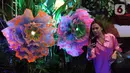 Pengunjung berfoto dengan bunga di Senayan City, Jakarta, Senin (14/12/2022). Senayan City menghadirkan Festive Season – The Festive Mood mulai tanggal 12 Desember – 8 Januari 2023, salah satunya Avatar Pandora Experience. (Liputan6.com/Herman Zakharia)