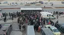 Foto udara menunjukkan pengungsi Suriah yang tinggal di Turki menunggu untuk naik bus melalui penyeberangan perbatasan Bab al-Hawa utara, pada 17 Februari 2023, saat mereka kembali ke Suriah setelah gempa bumi yang mematikan. Turki minggu ini mengizinkan warga Suriah di bawah perlindungannya yang memegang kartu identitas dari salah satu provinsi yang dilanda gempa untuk pergi antara tiga dan enam bulan. (AFP/Omar Haj Kadour)
