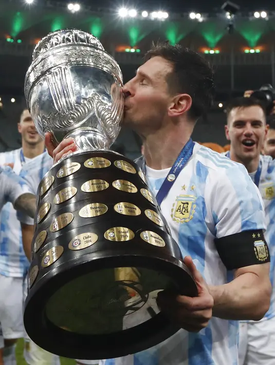Penyerang Argentina, Lionel Messi mencium trofi setelah mengalahkan Brasil 1-0 dalam pertandingan sepak bola final Copa America di stadion Maracana di Rio de Janeiro, Brasil, Minggu (11/7/2021). Kemenangan di final ini sangat bersejarah bagi Lionel Messi. (AP Photo/Bruna Prado)