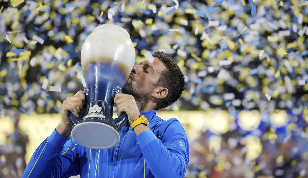 Petenis asal Serbia Novak Djokovic mencium trofi saat selebrasi menjuarai ATP Cincinnati Open 2023 dengan mengalahkan petenis asal Spanyol Carlos Alcaraz pada laga final di Mason, Ohio (20/8/2023). Djokovic menang dalam laga sengit 5-7, 7-6(9/7), 7-6(7/4). (AP Photo/Aaron Doster)