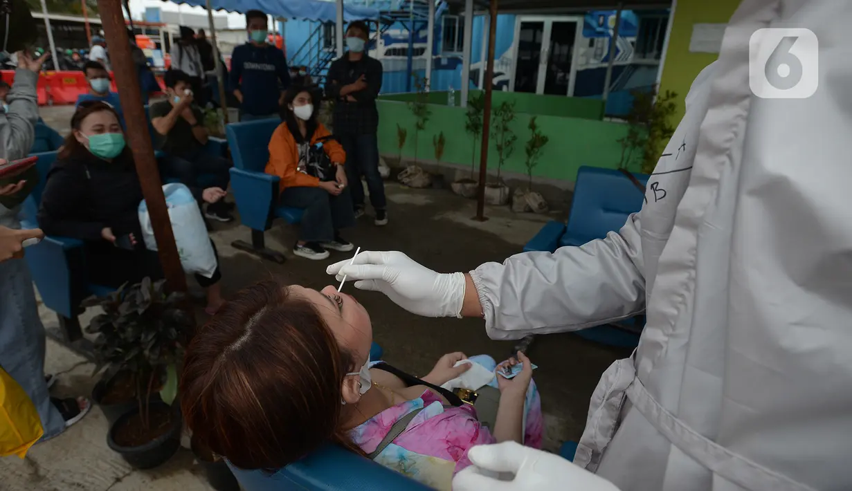 Petugas medis mengambil sampel lendir wisatawan untuk tes usap atau Swab Antigen di Pelabuhan Kali Adem, Jakarta, Kamis (31/12/2020). Pemeriksaan swab antigen wisatawan yang akan libur Tahun Baru di Kepulauan Seribu dilakukan untuk mencegah penyebaran COVID-19. (merdeka.com/Imam Buhori)