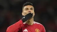 Gelandang Manchester United (MU), Casemiro, menyapa suporter di Old Trafford saat ditarik keluar dalam laga melawan Real Sociedad pada leg kedua 16 besar Liga Europa 2024/2025, Jumat (14/3/2025) dini hari WIB. (AP Photo/Dave Thompson)