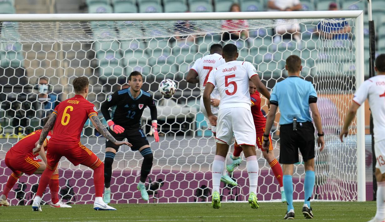Swiss kembali menguasai jalannya laga di awal babak kedua. Pada menit ke-49, striker Breel Embolo menghukum barisan belakang Wales yang terkesan membiarkannya untuk menyambut umpan Xherdan Shaqiri lewat tandukannya yang berujung gol. Swiss memimpin 1-0. (Foto: AP/Darko Vojinovic/Pool)