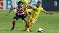 Bek Madura United, Asep Berlian (kiri) berebut bola dengan pemain Bhayangkara FC, Paulo Sergio Moreira dilanjutan Liga 1 Indonesia di Stadion Patriot Chandrabhaga, Bekasi, Kamis (13/7). Bhayangkara FC unggul 2-1. (Liputan6.com/Helmi Fithriansyah)
