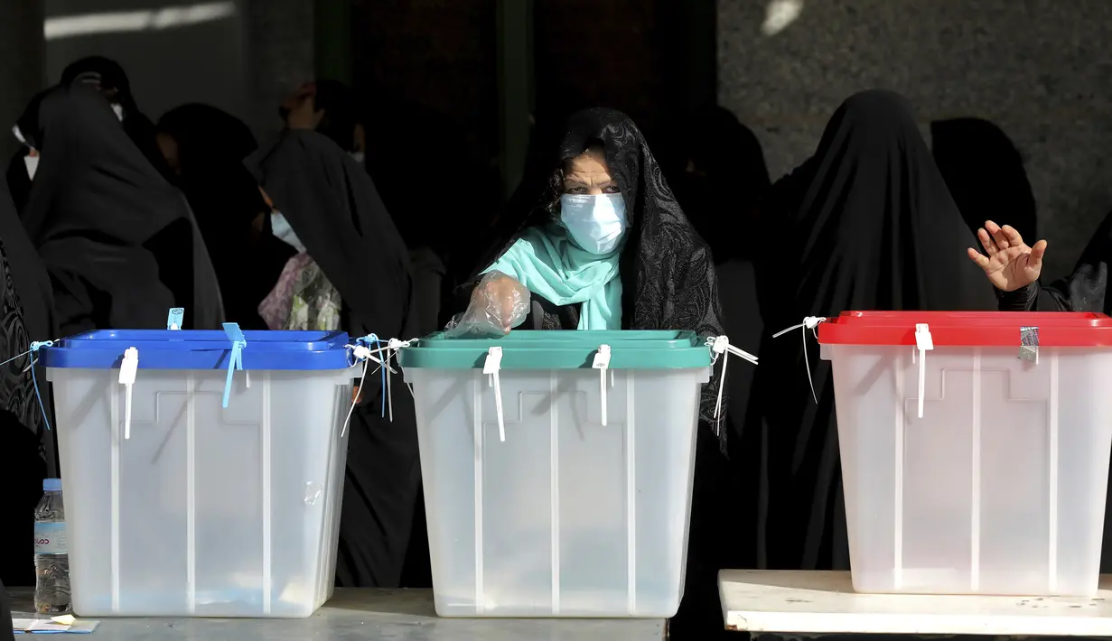 Seorang warga memberikan suaranya untuk pemilihan presiden di sebuah tempat pemungutan suara di Teheran, Iran, Jumat (18/6/2021). Warga Iran mulai memberikan suaranya dalam pemilihan presiden. (AP Photo/Ebrahim Noroozi)