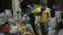 Seorang penjaga toko menimbang barang dagangan di pasar utama Shurja di pusat Baghdad, Irak, pada 22 Maret 2022. Melonjaknya harga energi dan makanan yang dipicu oleh invasi Rusia ke Ukraina mendorong beberapa negara Timur Tengah ke tepi jurang.  (AP Photo/Hadi Mizban)