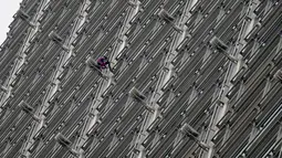 Alain Robert yang dijuluki 'French Spiderman' memanjat gedung pencakar langit Cheung Kong Center di Hong Kong, Jumat (16/8/2019). Alain Robert membentangkan spanduk perdamaian ketika pusat bisnis tersebut mengalami masalah internal dan maraknya demonstrasi. (AP Photo/Vincent Thian)