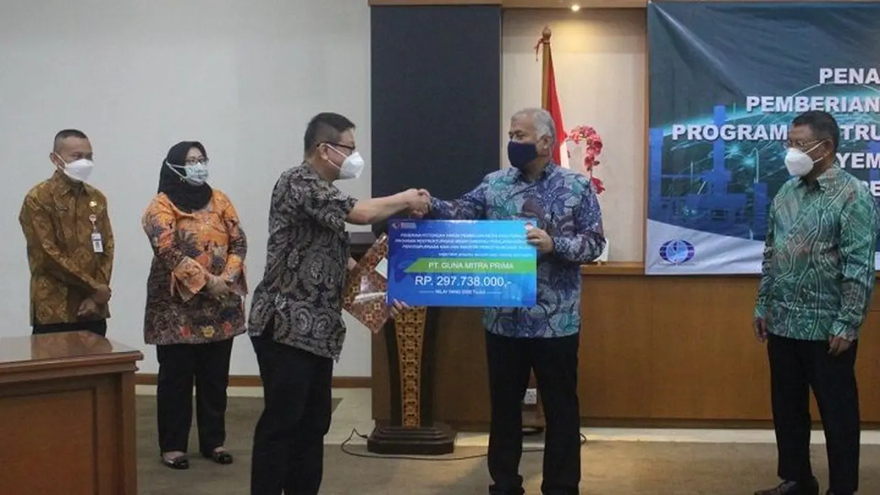 Sekjen Kementerian Perindustrian Dody Widodo menyampaikan Potongan Harga Pembelian Mesin atau Peralatan Industri Penyempurnaan Kain dan Industri Pencetakan Kain ke Direktur PT Guna Mitra Prima Fritze Lolin Handary. (Dok Kemenperin).