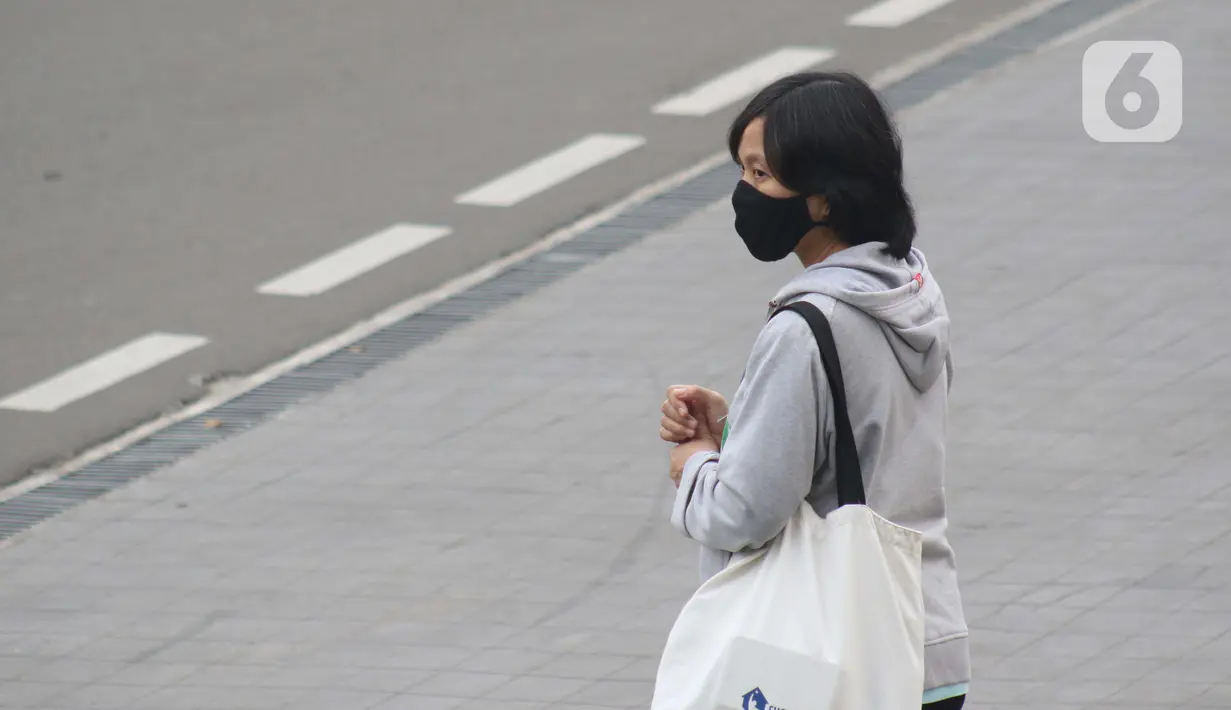 Warga mengenakan masker menanti angkutan umum di Jalan Jenderal Sudirman, Jakarta, Kamis (9/7/2020). Berdasar data yang diumumkan pemerintah pada Kamis (9/7) ada penambahan 2.657 orang yang terinfeksi COVID-19 sehingga jumlah penderita menjadi 70.736. (Liputan6.com/Helmi Fithriansyah)