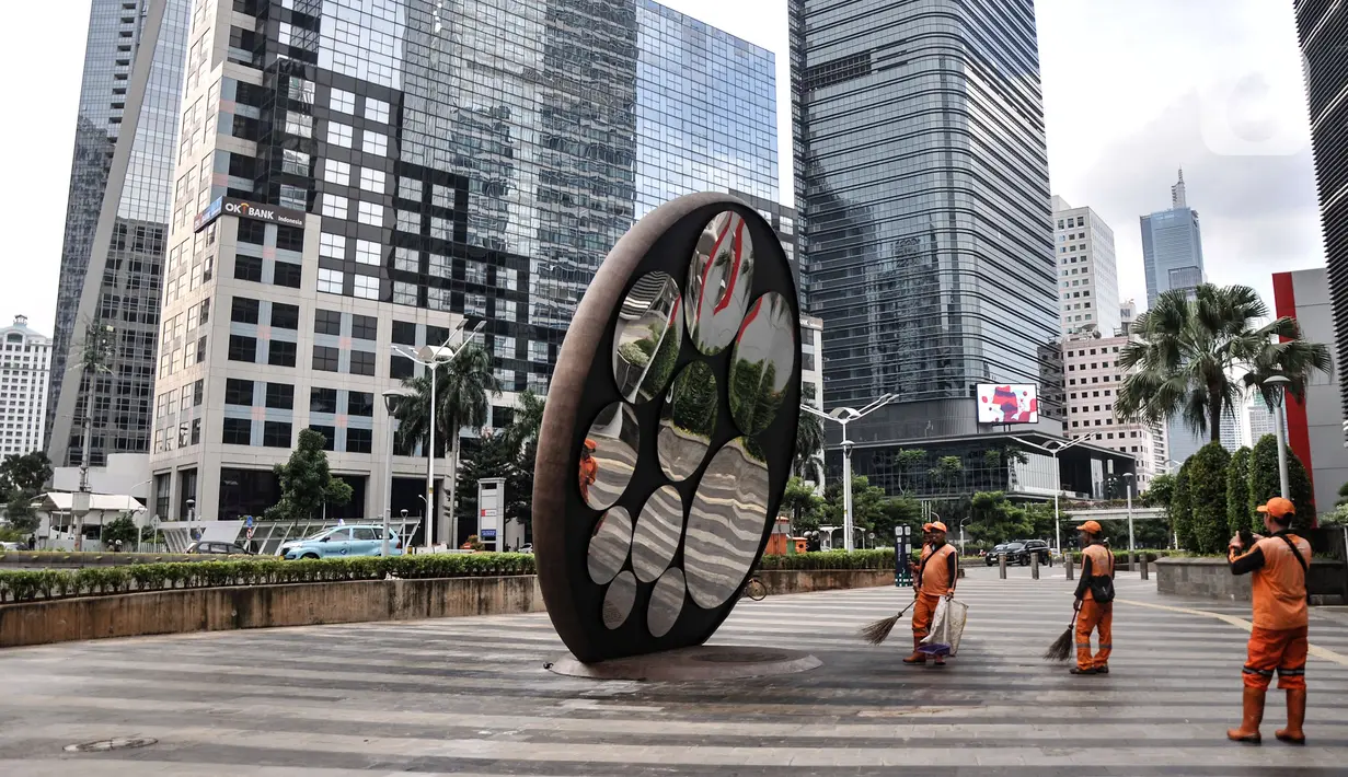 Petugas Penanganan Prasarana dan Sarana Umum (PPSU) beraktivitas dekat Tugu Sepeda di Jalan Jenderal Sudirman, Jakarta Pusat, Minggu (23/10/2022). Tugu tersebut sebagai bentuk penghargaan bagi pengguna sepeda di Ibu Kota. (merdeka.com/Iqbal S. Nugroho)