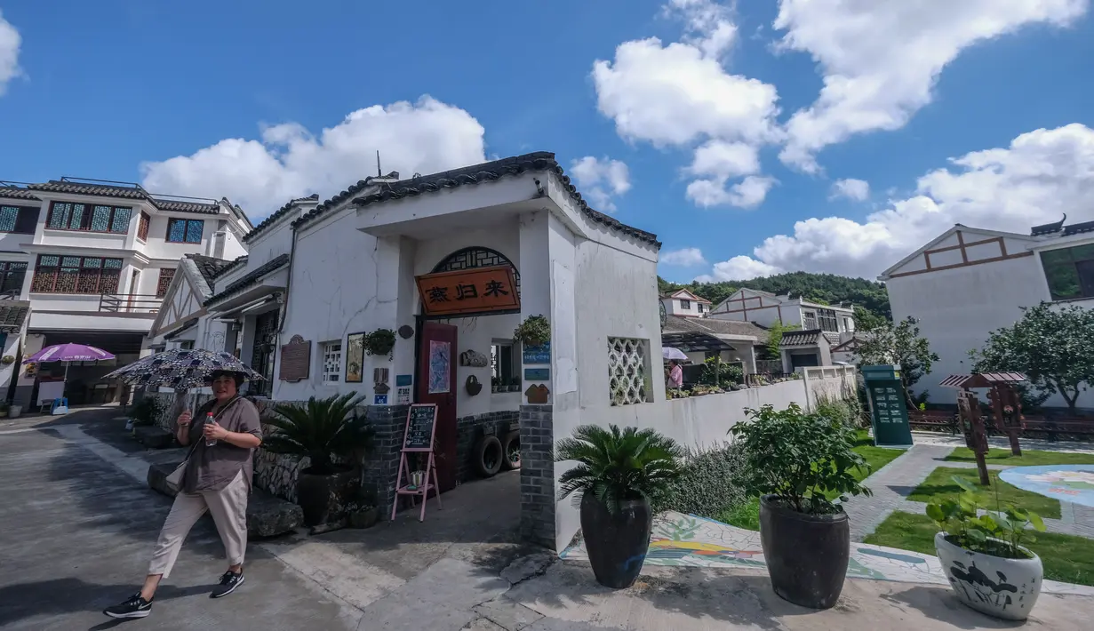 Turis berjalan keluar dari fasilitas agrowisata di Desa Xinjian di Ganlan, Distrik Dinghai, Provinsi Zhejiang, China (3/8/2020). Dalam beberapa tahun terakhir, otoritas Distrik Dinghai mengerahkan segala upaya untuk meningkatkan sanitasi dan daya tarik wisata di daerah pedesaannya. (Xinhua/Xu Yu)