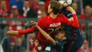 Penyerang Muenchen, Thomas Muller berebut bola dengan dua pemain Atletico Madrid di leg kedua semifinal Liga Champions di Allianz Arena (4/5). Meski kalah 2-1 dari Munchen, Atletico melaju ke final dengan aggregat gol tandang. (Reuters/Kai Pfaffenbach)