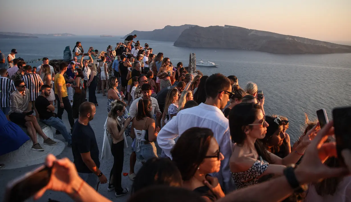 Wisatawan menunggu matahari terbenam di desa Oia di pulau Santorini, Yunani pada 20 Juli 2024. (Aris Oikonomou / AFP)