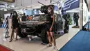 Sales Promotion Girl (SPG) berpose di depan kendaraan tempur yang dipamerkan dalam Indo Defence 2022 Expo & Forum di JIExpo, Kemayoran, Jakarta, Rabu (2/11/2022). Kementerian Pertahanan bersama PT Napindo Media Ashatama menggelar pameran industri pertahanan terbesar se-Asia Tenggara bertemakan “Peace, Prosperity, Strong Defence” yang diikuti 905 perusahaan dari 59 negara dan berlangsung hingga 5 November mendatang. (merdeka.com/Iqbal S. Nugroho)