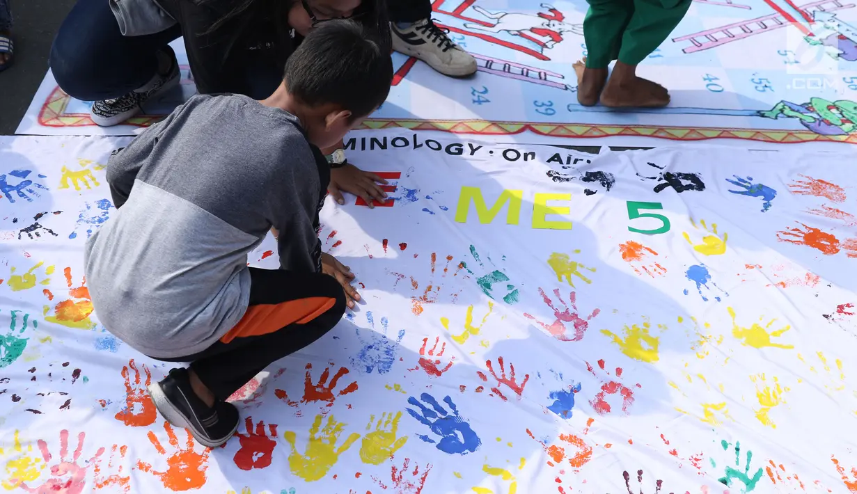 Seorang anak bermain cap tangan saat gelaran Car Free Day di kawasan Bundaran HI, Jakarta, Minggu (18/11). Permainan ini dihelat oleh Mahasiswa jurusan Kriminologi Fisip UI bertujuan mengurangi anak-anak bermain gawai. (Liputan6.com/Helmi Fithriansyah)
