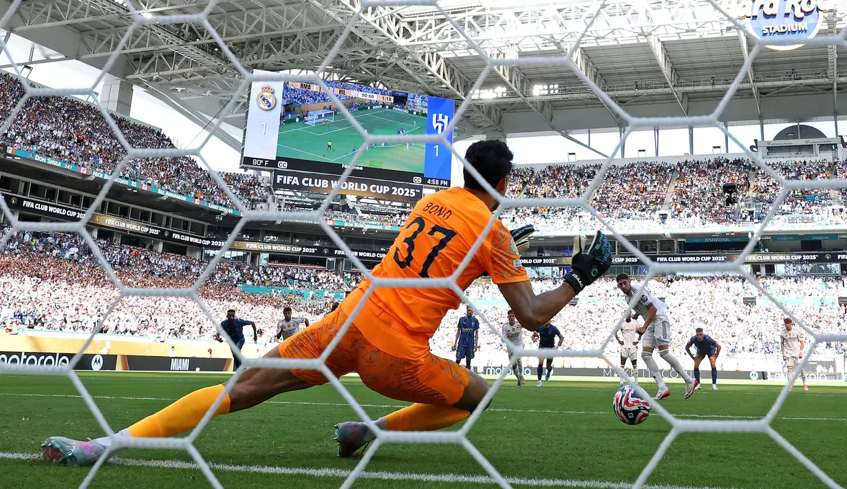 Kiper Al Hilal, Yassine Bounou menggagalkan tendangan penalti pemain Real Madrid, Federico Valverde dalam laga Grup H Piala Dunia Antarklub 2025 di Hard Rock stadium, Miami, Amerika Serikat, Kamis (19/06/2025) WIB. (AFP/Dan Mullan)