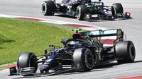 Pembalap Mercedes, Valtteri Bottas memimpin lomba Formula 1 GP Austria di Spielberg, diikuti rekan setim Lewis Hamilton di posisi kedua, Minggu (5/7/2020). (Joe Klamar/Pool via AP)