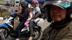 Pemudik sepeda motor dengan membawa anak mengantre untuk mengisi bahan bakar di SPBU kawasan Pantura di wilayah Brebes, Jawa Tengah, Kamis (22/6). Meski berbahaya, sejumlah pemudik masih nekat membawa anak mereka dengan motor. (Liputan6.com/Johan Tallo)