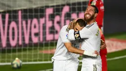 Bek Real Madrid, Sergio Ramos, merayakan gol yang dicetak Karim Benzema ke gawang Villarreal pada laga lanjutan La Liga pekan ke-37 di Estadio Alfredo Di Stefano, Jumat (17/7/2020) dini hari WIB. Real Madrid menang 2-1 atas Villarreal. (AFP/Gabriel Bouys)